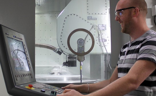 Man som kör en CNC maskin