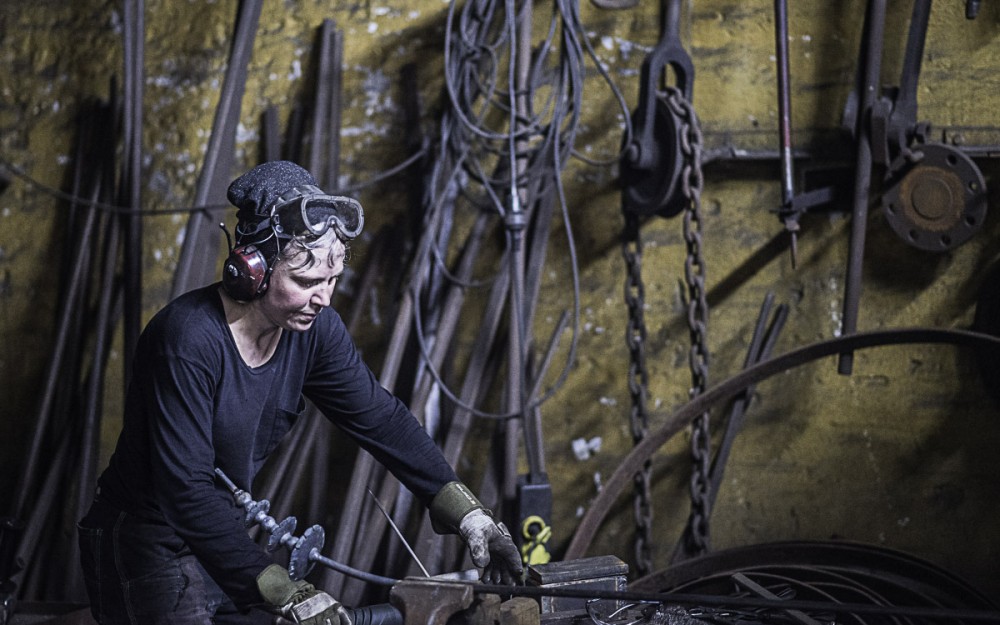 Smed som arbetar i smedja